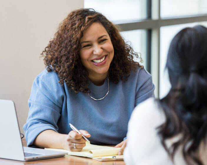 Woman smiling while signing a document