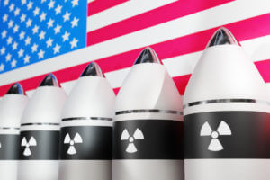 A set of nuclear-armed rockets isolated against a clean white background, featuring a close-up view of warheads adorned with the United States flag.